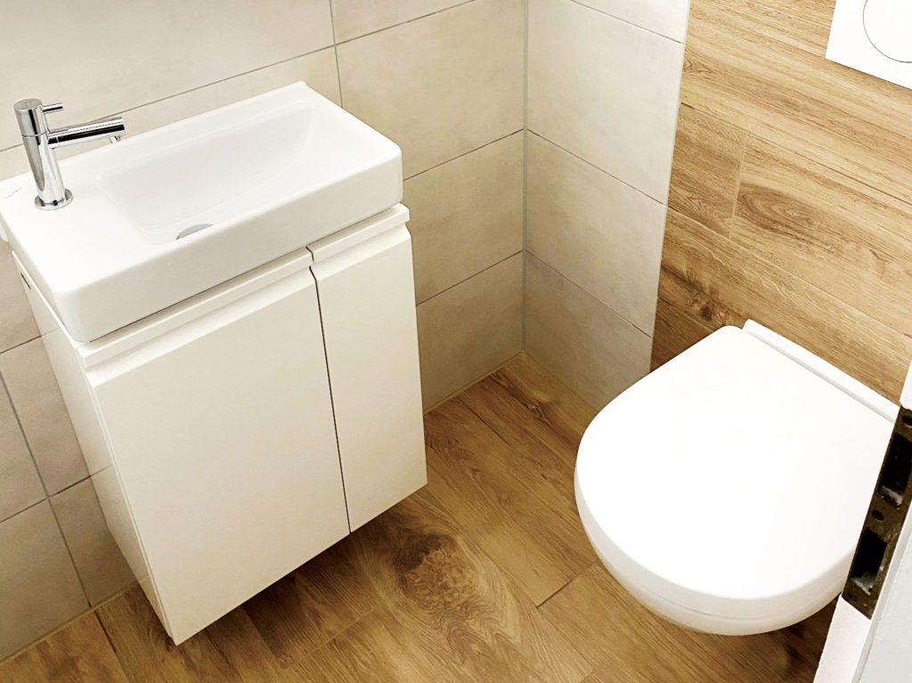 WC-Ecke: Kleiner Raum mit WC, Waschbecken und Holzelementen.
