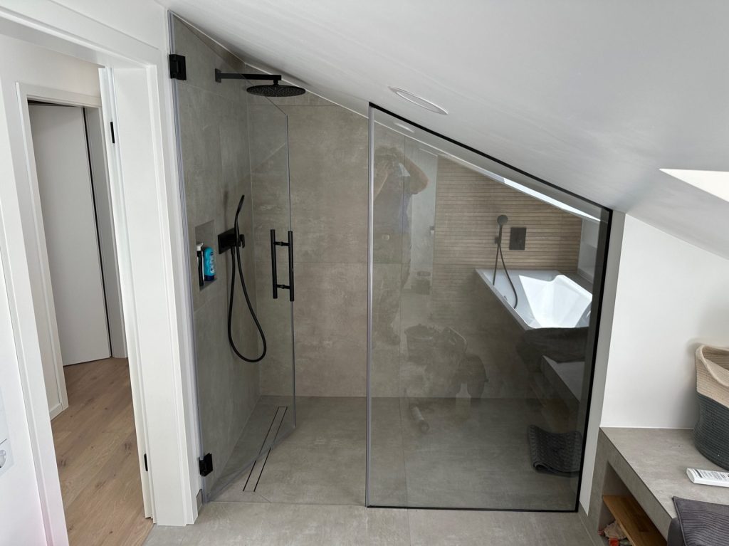 Duschkabine: Glasduschwand in einem Badezimmer mit Dachschräge.