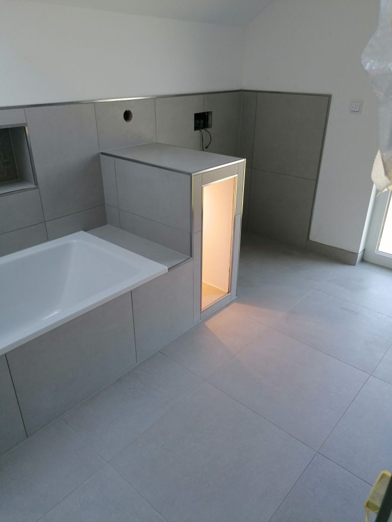 Duschrinne: Flache Dusche mit langer Edelstahl-Ablaufrinne.