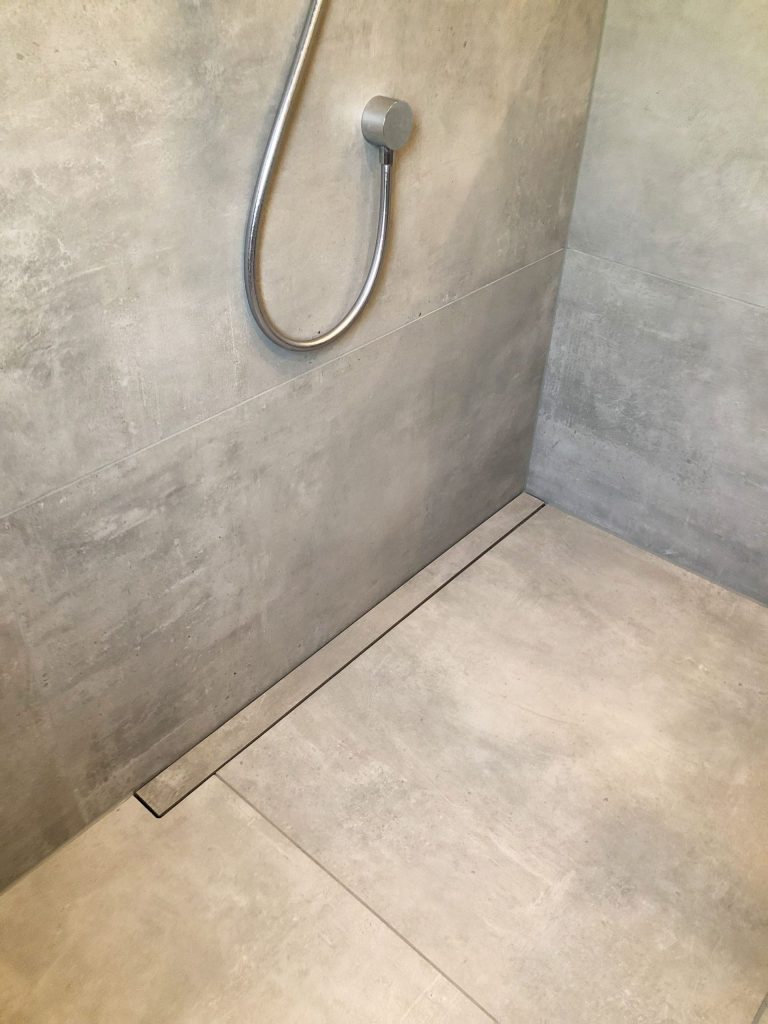 Badewanne mit Korb: Weiße Wanne neben einer Ablage mit Flechtkorb.