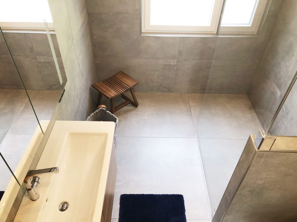 Dachschrägendusche: Dusche mit einer Glaswand, die an die Dachschräge angepasst ist.